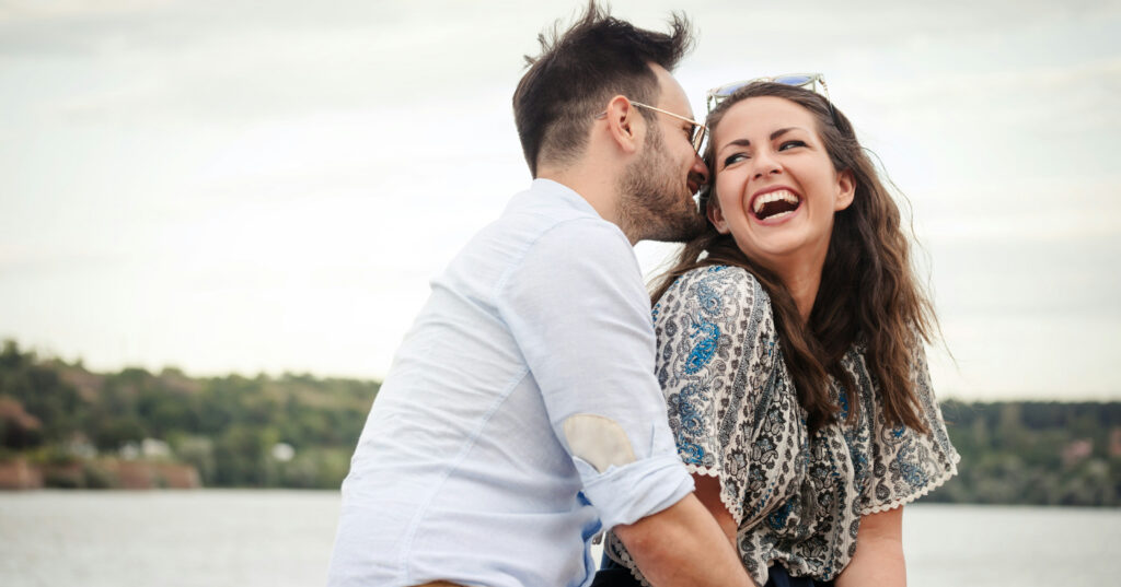 Darstellung von einem Paar vor der Kulisse eines Sees.